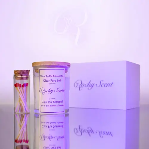 Lavender-scented natural soy candle in a transparent glass jar, part of Rocky Scent’s Lull Essence collection, displayed with match jar and gift box.